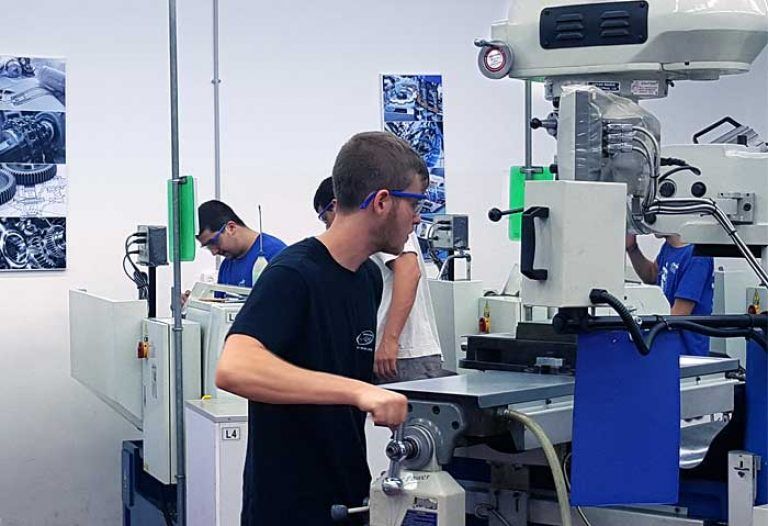 a young student works on the lathe at the technological educational center